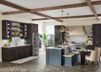 Kitchen with two-tone cabinets featuring rich brown lower cabinets and deep blue upper cabinets, white countertops, and stainless steel appliances.