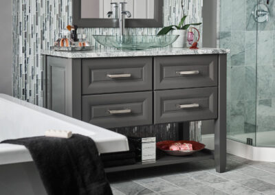 Double-sink bathroom vanity with gray shaker cabinets, white countertop, and brushed nickel faucets under a large mirror.