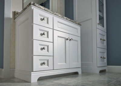 Close up of white cabinets with marble countertops.