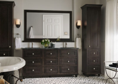 Dark brown bathroom cabinets with two tall shelving usnits.