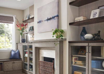 Living room with white built-in cabinets and floating shelves on both sides of a fireplace.