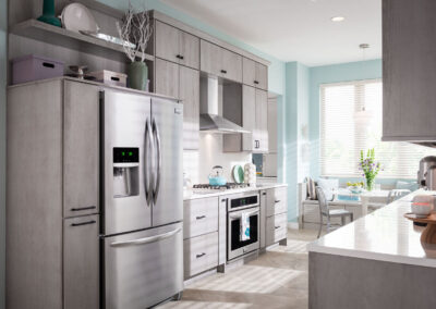 Kitchen with gray-blue cabinets, white countertops, and stainless steel appliances.