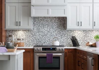 Modern kitchen with brown lower cabinets, grey upper cabinets, and white countertops.