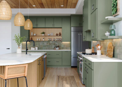 Kitchen with sage green cabinets, white countertops, and dark hardware.