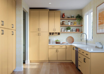Kitchen with light yellow cabinets, white countertops, and a farmhouse sink under a window.