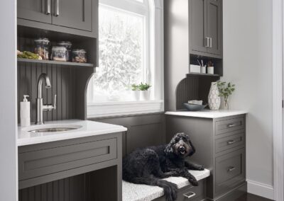 Built-in mudroom bench with white cabinetry, upper cubbies, and decorative pillows.