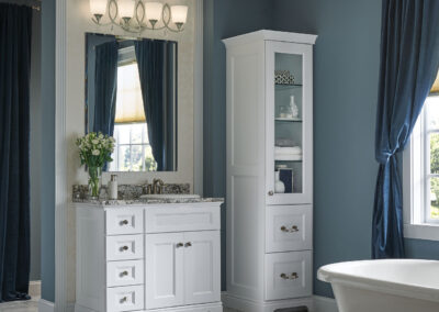 White cabinets with marble countertops in a blue bathroom.