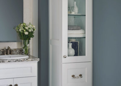 White cabinets with marble countertops in a blue bathroom.
