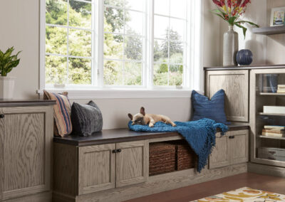Built-in window seat with white cabinetry, drawer storage, and decorative pillows.